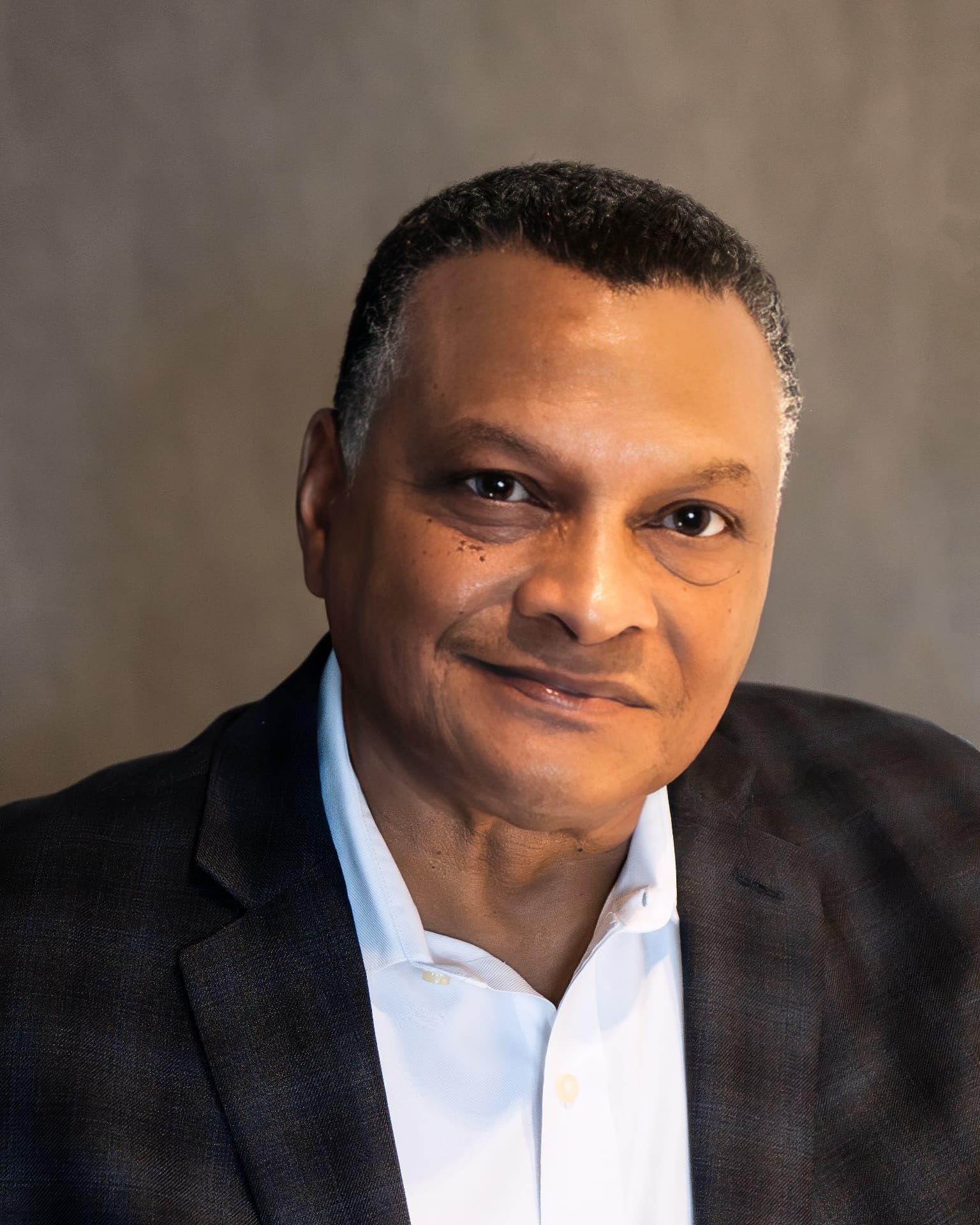 Portrait headshot of Randy Powell in a dark jacket and open-collar shirt.